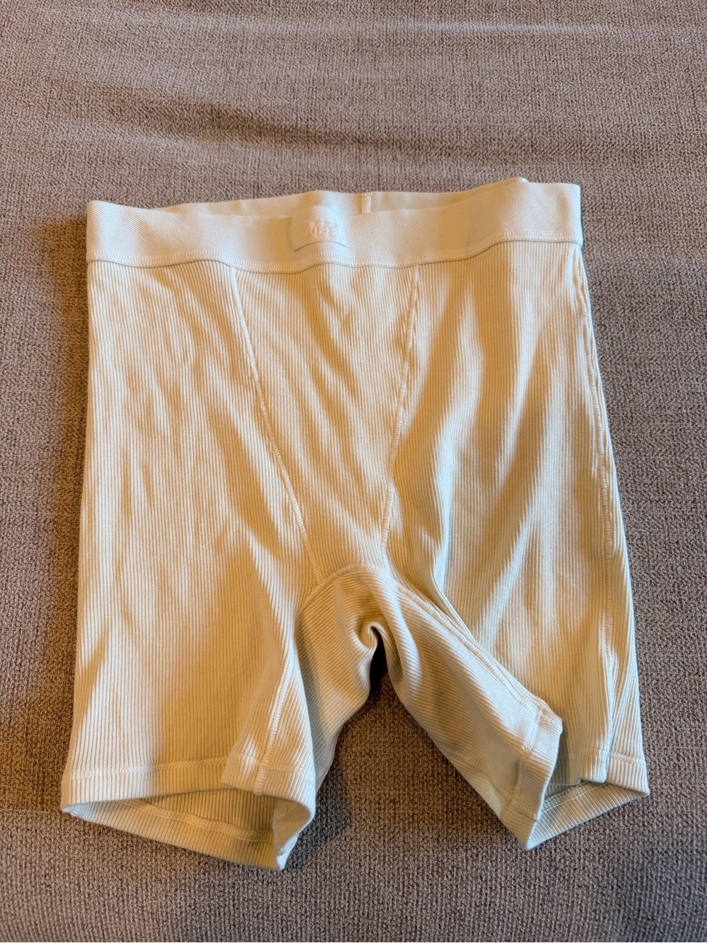 SKIMS Cotton Rib Boxers crafted from a soft, cream-colored ribbed cotton fabric